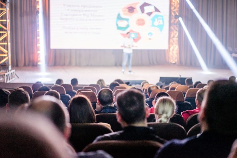 Audience watching a keynote on a large conference stage